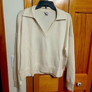 Ivory Danskin lounge top. Size large. V neck spread collar long sleeves. NWT